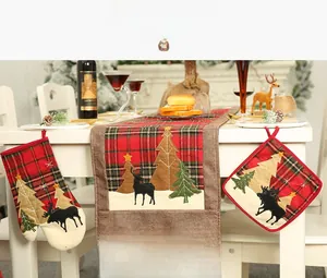 Plaid Christmas kitchen set with table runner, oven mitt, and pot holder on a table