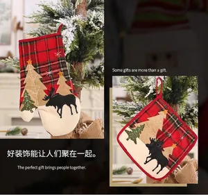 Detail view of red plaid Christmas stocking and heat-resistant mat with reindeer motif