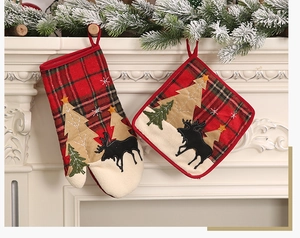 Close-up of Christmas oven mitt and pot holder set with red plaid and reindeer embroidery