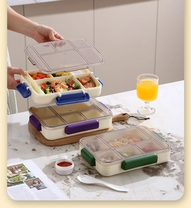 Detail view of leak-proof lunch box with colorful buckles, sauce cup and fork