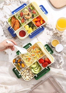 Multi-compartment lunch box with utensils shown in a bright lifestyle setting