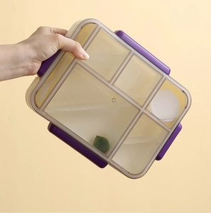 Detail of a 5-compartment lunch box with secure purple side buckles and a sauce container