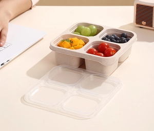 Detail of four-compartment eco-friendly bento box filled with fresh fruits on a desk