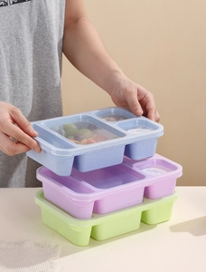 Detail of multi-compartment food containers stacked in blue, purple, and green colors