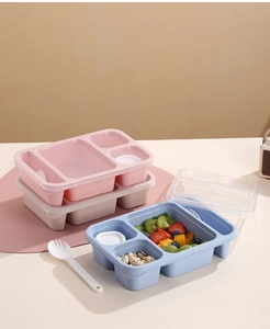 Detail showing compartmentalized bento box with transparent lid and reusable cutlery