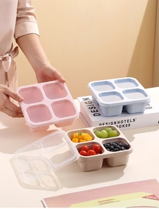 Close-up of stackable four-compartment bento lunch boxes with transparent airtight lids