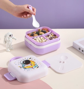 Close-up of dual-layer purple bento box with astronaut print and 3-grid compartment