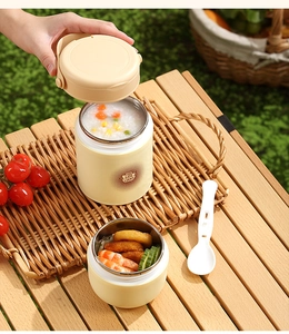 Detail of a cream 304 stainless steel lunch jar with a foldable spoon on a picnic table