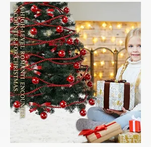 Nahaufnahme von roten Weihnachtsbaum-Ornamenten mit glänzenden Kugeln und Samtschleifen