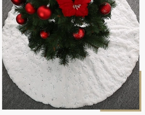Detailaufnahme weißer Weihnachtsbaumrock aus Kunstpelz mit schimmernden silbernen Schneeflocken