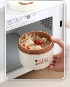 Détail d'une boîte à lunch isolée avec soupe placée dans un micro-ondes pour le chauffage