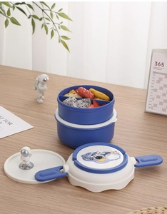 Detail of round double-layer bento box with blue clips and astronaut pattern