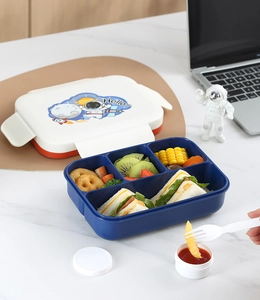 Dettaglio del portapranzo a quattro scomparti con coperchio astronauta e tazza per salse