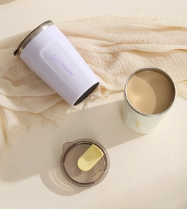 Close-up of insulated stainless steel coffee mugs with splash-proof lids and cartoon print