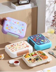 Detail of four-compartment portable lunch box with cartoon themes and sauce container