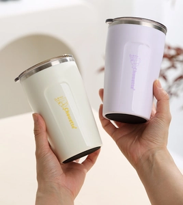 Detail of cream white and lavender stainless steel mugs with cute bear graphics