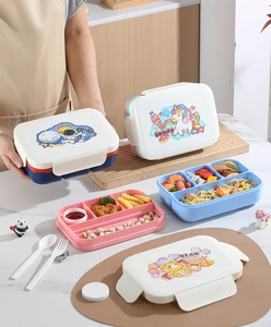Dettaglio del bento box a doppio strato con coperchio a cartoni, divisori e posate