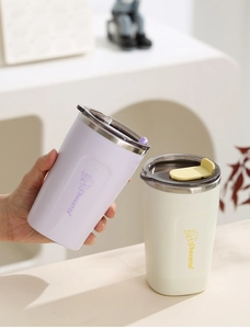 Detail of insulated stainless steel coffee mugs featuring cat illustrations and slide lids