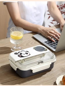 Detail of cute panda lunch box with three compartments and built-in cutlery storage