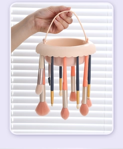 Pink makeup brush drying rack with multiple holes for hanging various brushes to dry