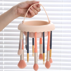 Portable makeup brush cleaning bowl and drying rack in peach silicone with handle