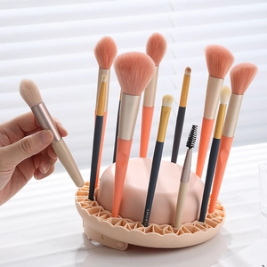 Pink makeup brush cleaning bowl and drying rack with a professional synthetic brush set
