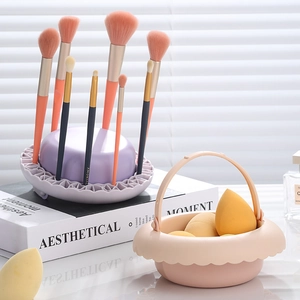 Purple makeup brush drying rack and pink sponge holder basket with brushes