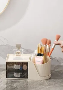 Detalle de organizador de cosméticos crema con cajones transparentes y porta pinceles