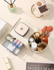 Macro view of cream vanity organizer featuring two clear drawers and a rotating brush holder