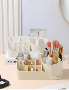 Detail view of cream desktop organizer with tiered compartments and brush holders