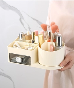 Detail of a beige cosmetic organizer with a rotating brush holder and transparent drawer