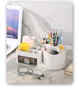 Close-up of a white desktop organizer with transparent drawer and rotating pencil holder