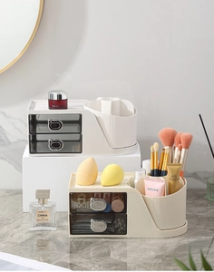 Close-up of a desktop makeup organizer with translucent drawers and tiered open slots