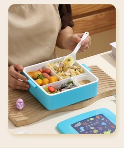 Détail de la boîte bento bleue à 4 compartiments avec couvercle dinosaure et cuillère