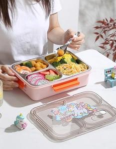 Detail van roze 3-vaks roestvrijstalen bento box met eenhoorn deksel en maaltijd setup