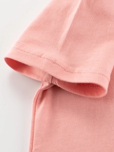 Rosa Mädchen T-Shirt aus Baumwolle zeigt detaillierte Ärmelsäume und glatte Nähte