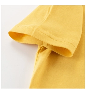 Detailed macro view of sleeve seam and double-needle stitching on yellow cotton kids T-shirt