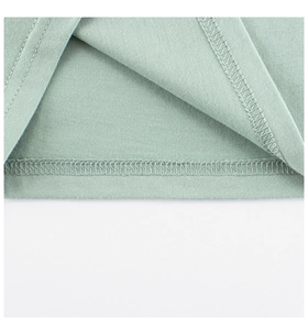 Dettaglio della cucitura piatta a doppio ago sull'orlo della t-shirt in cotone menta