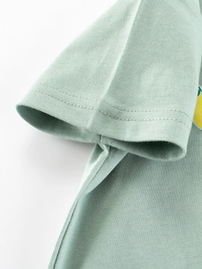 Dettaglio della manica di una T-shirt in cotone verde con cuciture doppie e trama a maglia