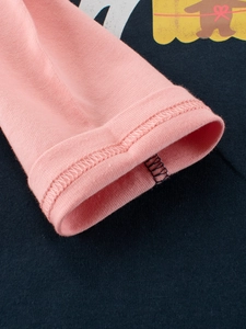 Gros plan des poignets contrastés rose et bleu marine sur un t-shirt en coton fille