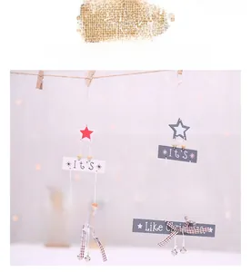 Detailed view of wood Christmas tree pendants with star toppers and ribbon bells