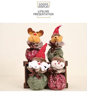 Detail of four Christmas drawstring bags with Santa and snowman 3D dolls on rustic burlap