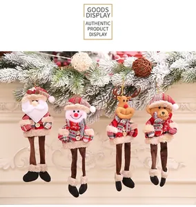 Set of four Christmas plush ornaments with long legs hanging on a snow-covered pine branch
