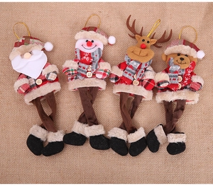 Flat lay of four plush Christmas ornaments with plaid patterns and long dangling legs