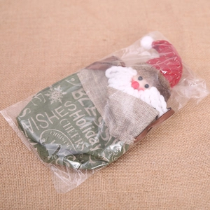 Christmas burlap gift bag featuring a 3D Santa Claus doll and festive holiday greetings