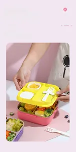 Detailed view of pink three-compartment stainless steel bento box with yellow lid and fork