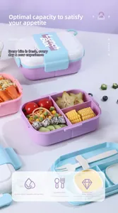 Close-up of divided lunch box compartments with fruit, noodles, and reusable cutlery set