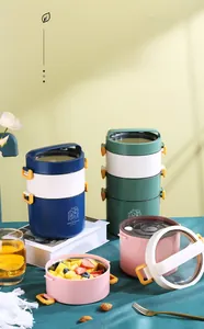 Detail of portable tiered lunch box with orange latches and stainless steel interior