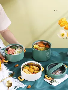 Three-layer circular lunch box with green and white tiers showing large capacity for meals