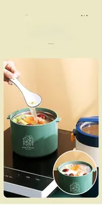 Detail view of mint green stainless steel lunch box liner heating on an induction cooker